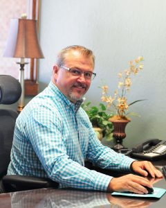 Dennis Malanca sits at his desk